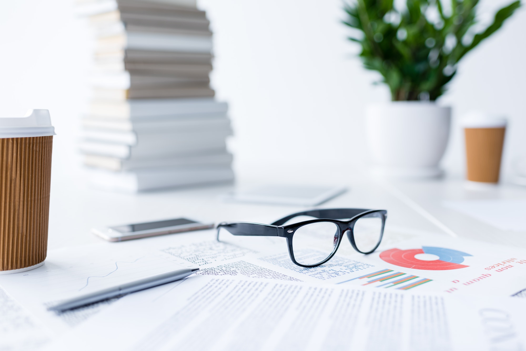 composition with eyeglasses and business documents on white desk